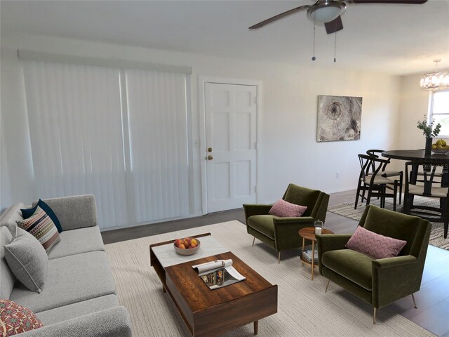 living room with ceiling fan with notable chandelier