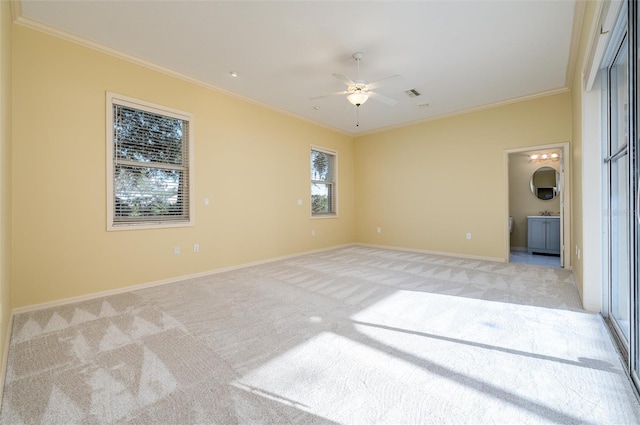 carpeted spare room with ceiling fan and crown molding