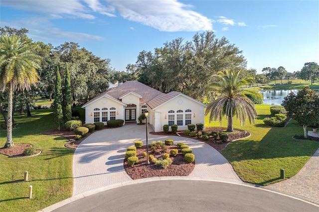 single story home featuring a water view, a front yard, and french doors