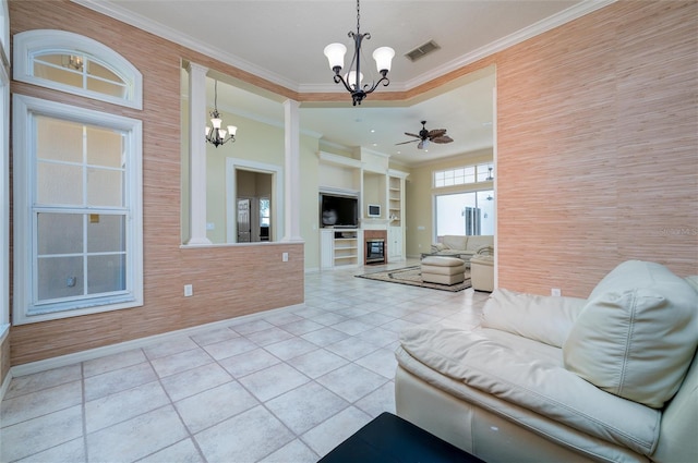 living room featuring built in features, a fireplace, light tile patterned floors, ceiling fan with notable chandelier, and ornamental molding