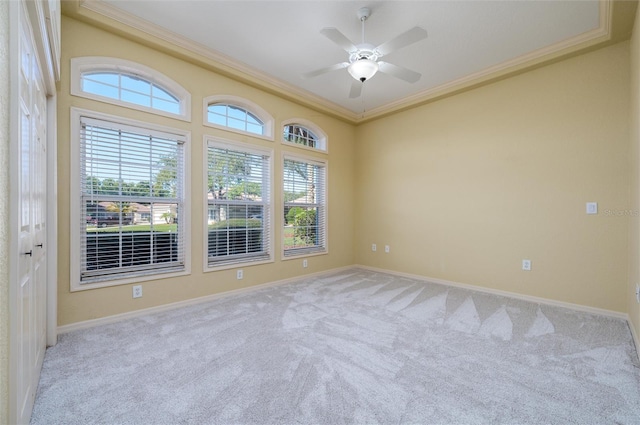 carpeted empty room with ceiling fan and crown molding