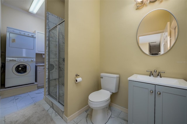 bathroom featuring vanity, a shower with door, toilet, ornamental molding, and stacked washer / dryer