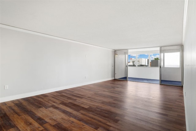 unfurnished living room featuring ornamental molding and dark hardwood / wood-style flooring