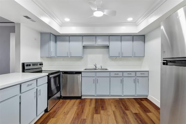 kitchen featuring light hardwood / wood-style floors, sink, stainless steel appliances, backsplash, and ceiling fan