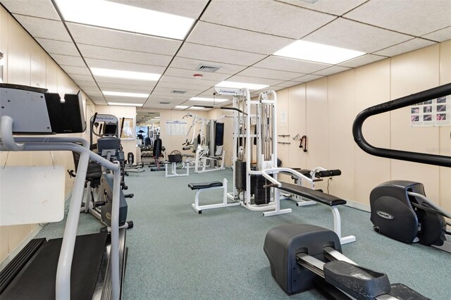 exercise room with carpet floors and a drop ceiling