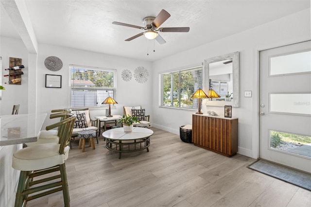 living area with ceiling fan and light hardwood / wood-style floors