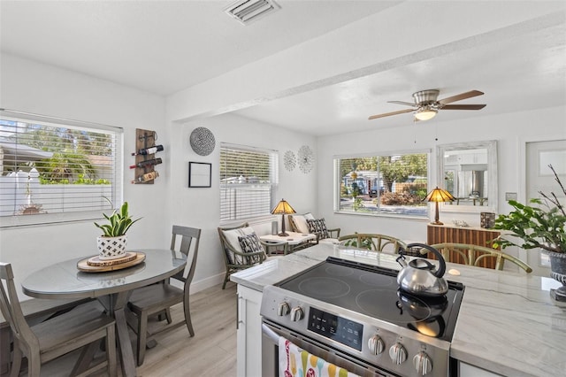 kitchen with ceiling fan, light wood-type flooring, and stainless steel electric range