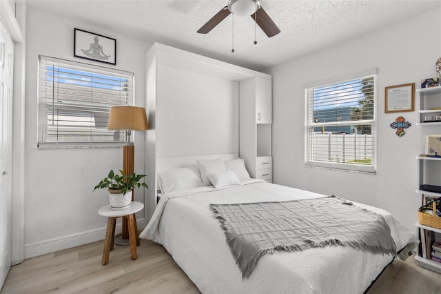 bedroom featuring a textured ceiling, ceiling fan, and light hardwood / wood-style flooring