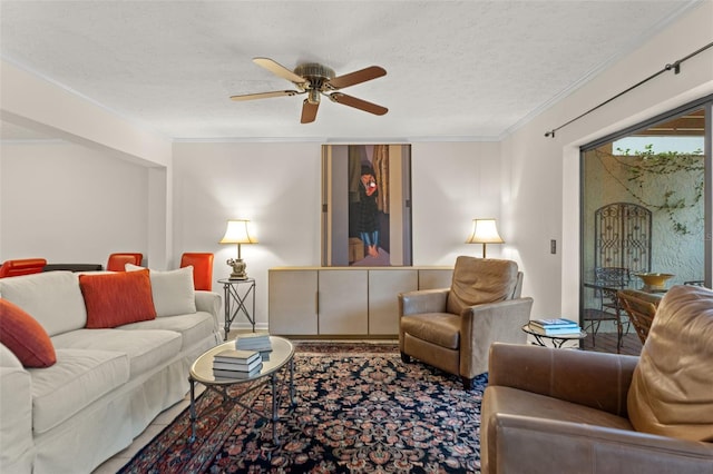 living room with crown molding, ceiling fan, and a textured ceiling