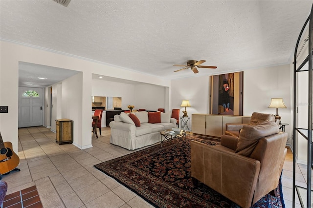 living room with light tile patterned flooring, ceiling fan, a textured ceiling, and crown molding