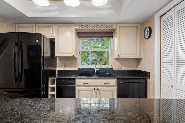 kitchen with dark stone counters, a raised ceiling, sink, and black appliances