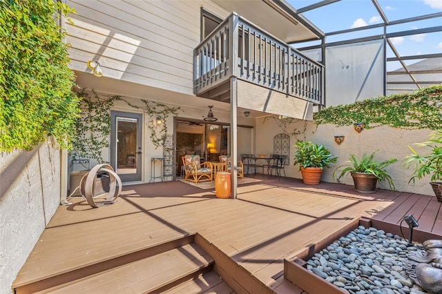 view of patio / terrace with ceiling fan, a balcony, and glass enclosure