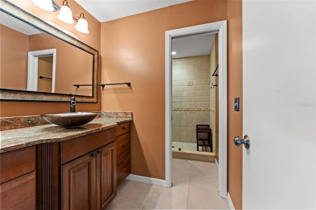 bathroom with tiled shower, tile patterned floors, and vanity