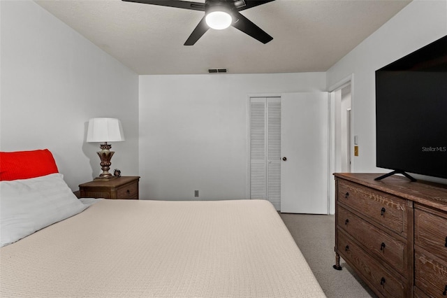 carpeted bedroom featuring a closet and ceiling fan