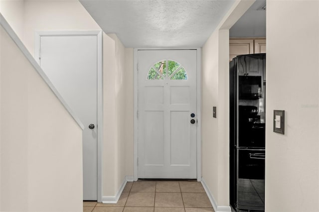 tiled foyer with a textured ceiling