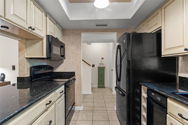 5313 Bayshore Blvd Unit 5313, Tampa, FL 33611 - kitchen with black appliances, cream cabinets, light tile patterned flooring, a ceiling fan, and dark stone counters