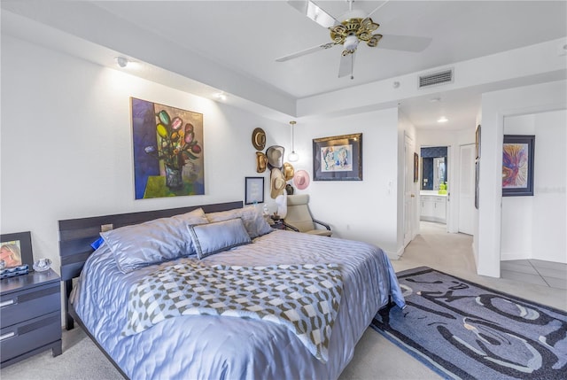 bedroom with ensuite bath, ceiling fan, and light colored carpet