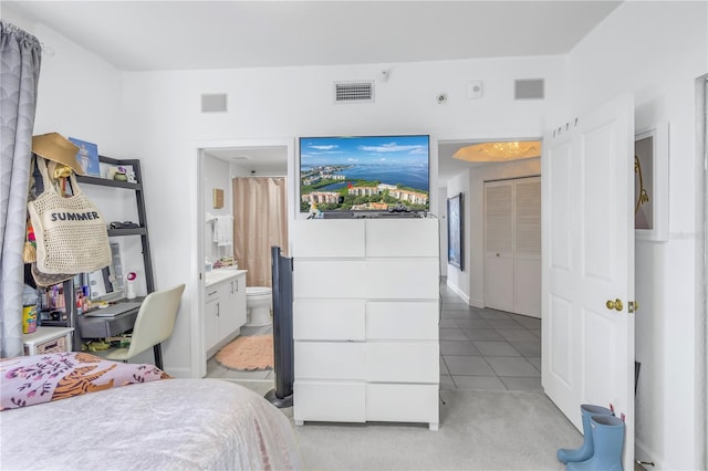 tiled bedroom with a closet and connected bathroom