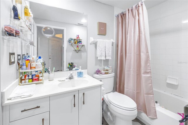 full bathroom with shower / tub combo with curtain, vanity, and toilet