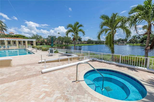 view of swimming pool featuring a patio area, a pergola, a hot tub, and a water view