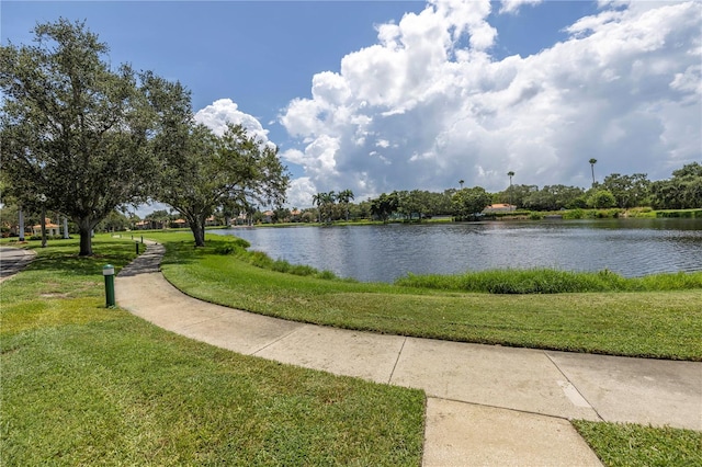 view of property's community with a yard and a water view