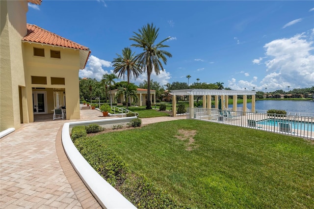 view of yard featuring a water view, a patio, a community pool, and a pergola