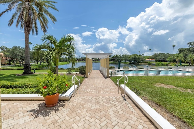 view of home's community featuring a lawn, a swimming pool, and a water view