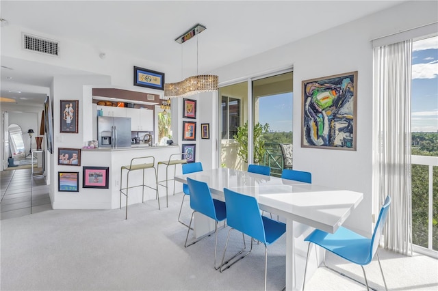 dining space with light carpet and plenty of natural light