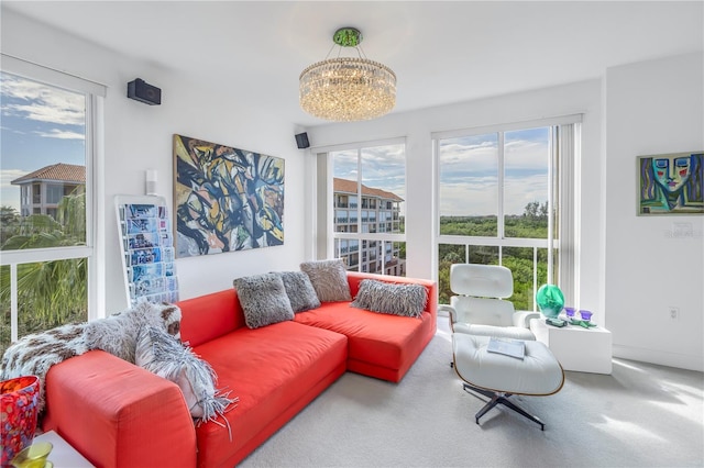 carpeted living room featuring a wealth of natural light and a chandelier