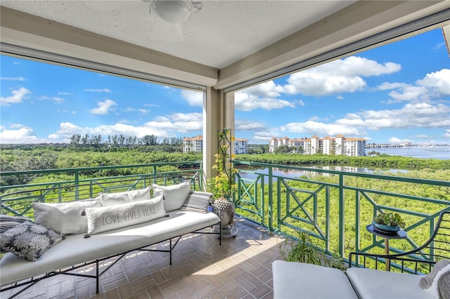 balcony featuring outdoor lounge area and a water view