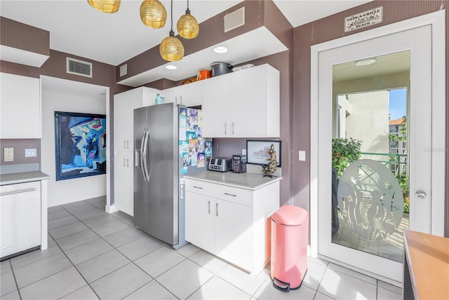 kitchen featuring decorative light fixtures, white cabinetry, dishwasher, light tile patterned floors, and stainless steel refrigerator with ice dispenser