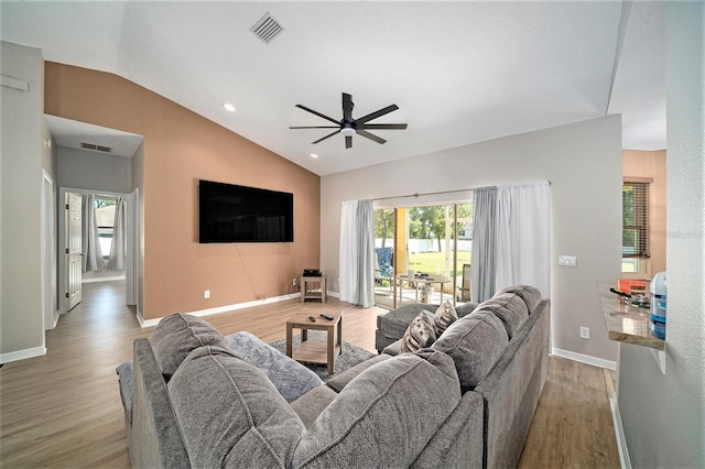 living room with ceiling fan, lofted ceiling, and light hardwood / wood-style floors