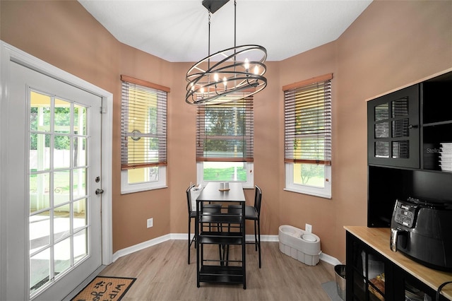 dining area featuring a chandelier, light hardwood / wood-style flooring, and a wealth of natural light