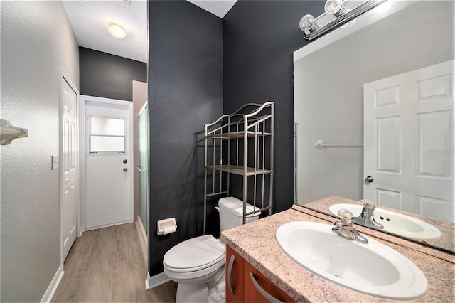 bathroom with hardwood / wood-style flooring, vanity, and toilet