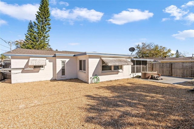 back of property featuring a hot tub and a patio area