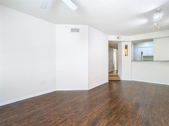 unfurnished living room featuring ceiling fan and dark hardwood / wood-style flooring