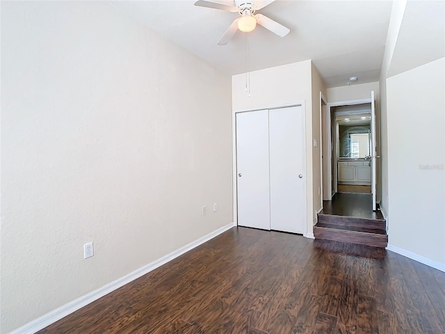 unfurnished bedroom featuring dark hardwood / wood-style floors, ceiling fan, and a closet