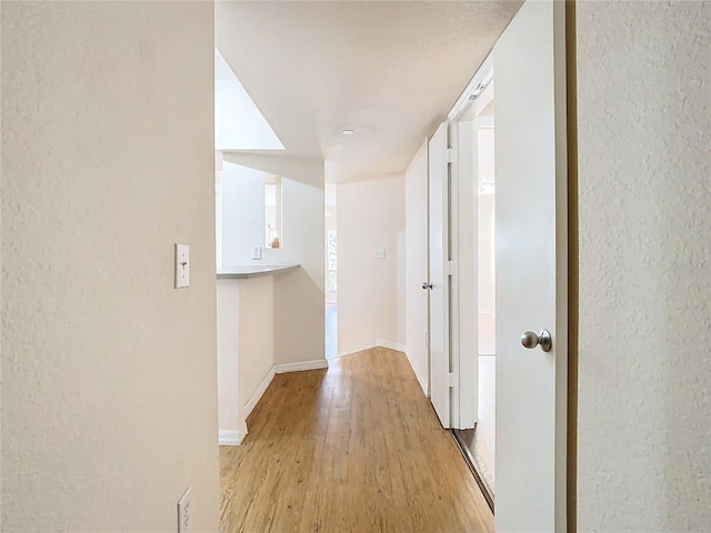 corridor with light hardwood / wood-style flooring