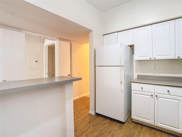 kitchen featuring light hardwood / wood-style flooring, white cabinetry, and white refrigerator