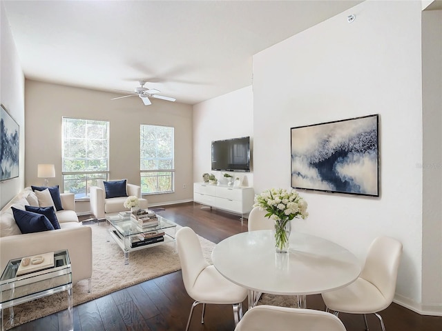 living room featuring ceiling fan and dark wood-type flooring