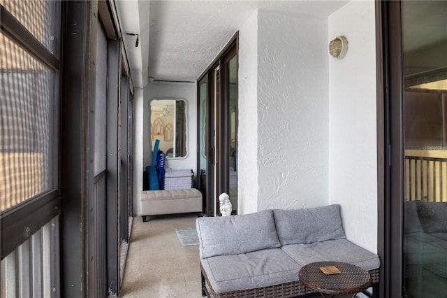 corridor with a textured ceiling and light colored carpet