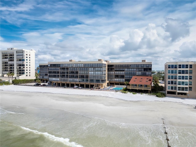 view of property with a water view and a beach view