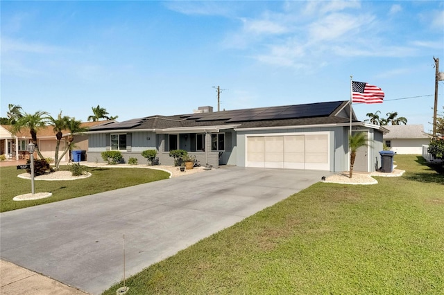 ranch-style home with a front yard, solar panels, and a garage