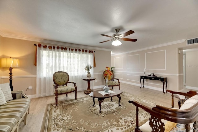 sitting room featuring light wood-type flooring, crown molding, and ceiling fan