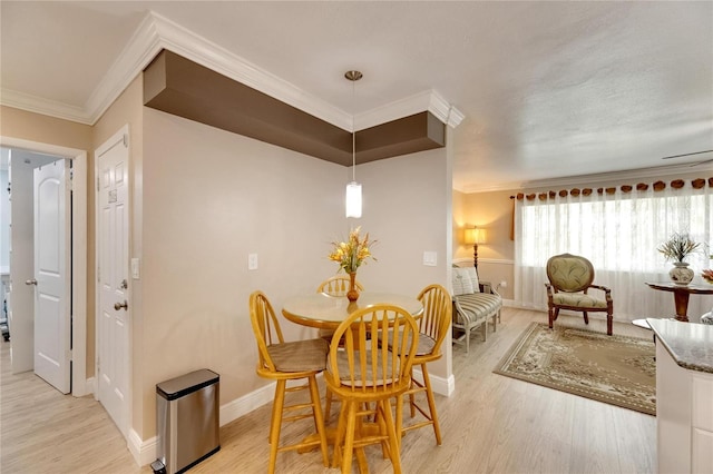 dining area with light hardwood / wood-style flooring and crown molding