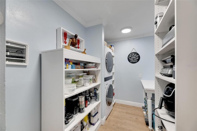 pantry featuring stacked washer and clothes dryer