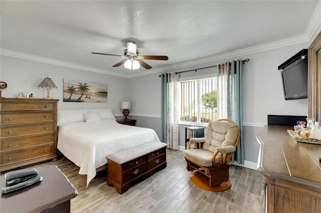 bedroom featuring ornamental molding, light wood-type flooring, and ceiling fan