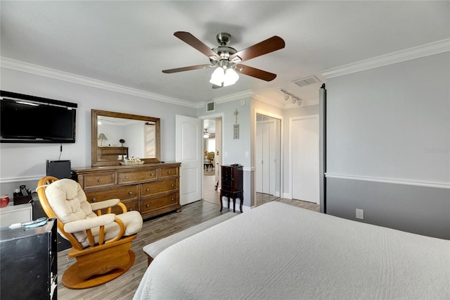 bedroom with ceiling fan, crown molding, and light hardwood / wood-style floors