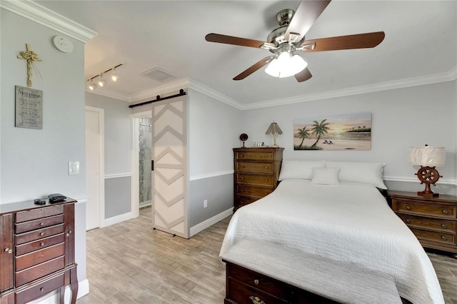 bedroom with rail lighting, a barn door, light wood-type flooring, crown molding, and ceiling fan