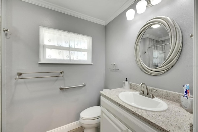 bathroom with ornamental molding, vanity, and toilet